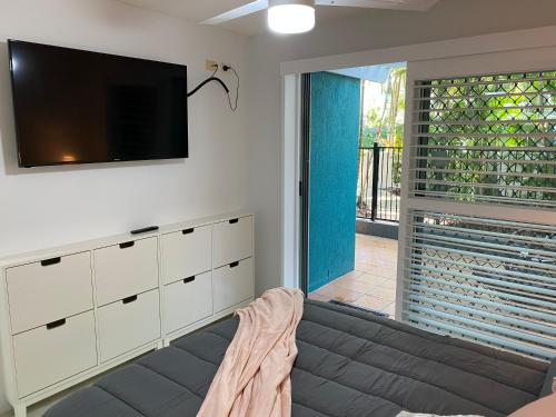 a living room with a flat screen tv on the wall at Kings Bay Apartments in Caloundra