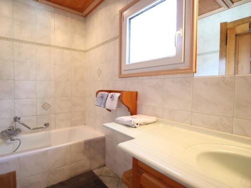 La salle de bains est pourvue d'une baignoire, d'un lavabo et d'une fenêtre. dans l'établissement Appartement Les Gets, 3 pièces, 6 personnes - FR-1-623-316, aux Gets