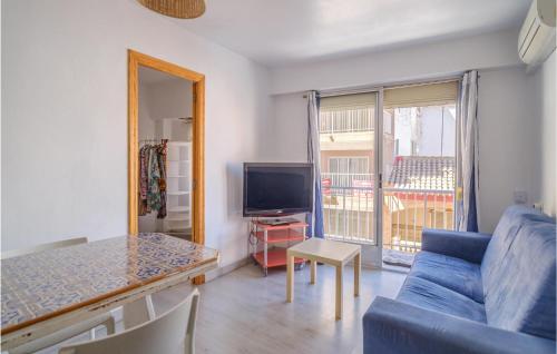 a living room with a blue couch and a television at 3 Bedroom Cozy Apartment In Sueca in Sueca