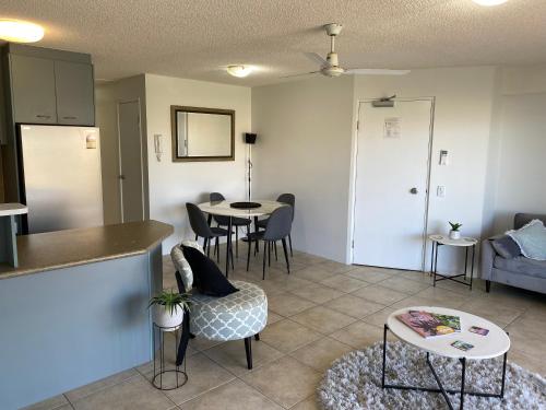 a living room with a kitchen and a table at Kings Bay Apartments in Caloundra