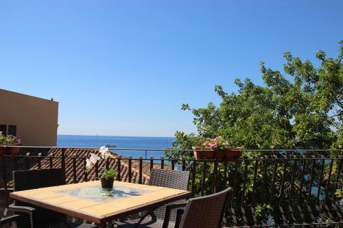 una mesa en un balcón con vistas al océano en Villa degli Ulivi, en Taormina