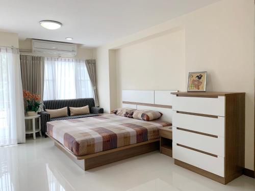 a bedroom with a bed and a dresser in it at Charming Resident near BTS Ekkamai Station in Bangkok