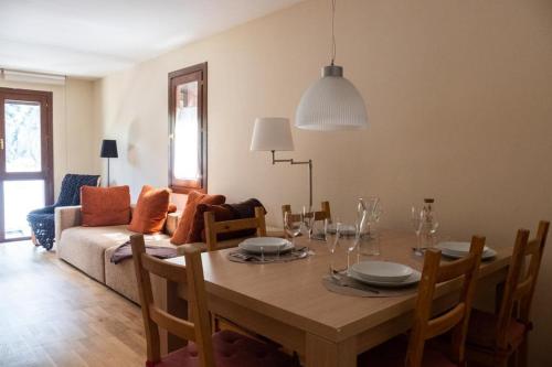 a dining room with a table and a couch at El Descanso del Sol - Apartamento en Pirineos in Plan