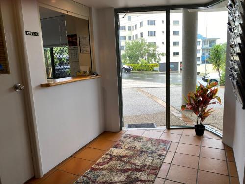 an open door with a potted plant in a hallway at Kings Bay Apartments in Caloundra