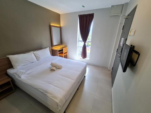 a bedroom with a white bed and a window at Ants Hotel in Kangar