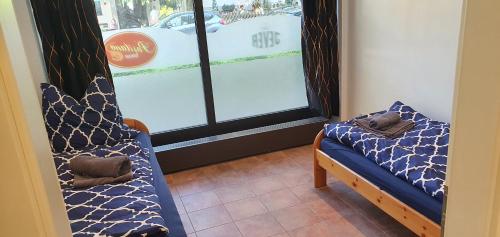 Zimmer mit 2 Betten vor einem Fenster in der Unterkunft Positano Apartments in Rosenheim