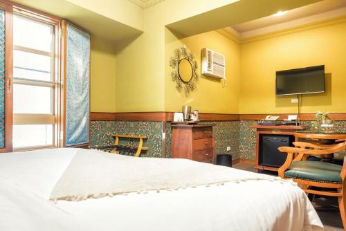 a bedroom with a bed and a desk and a television at 翠安儂風旅 in Taitung City
