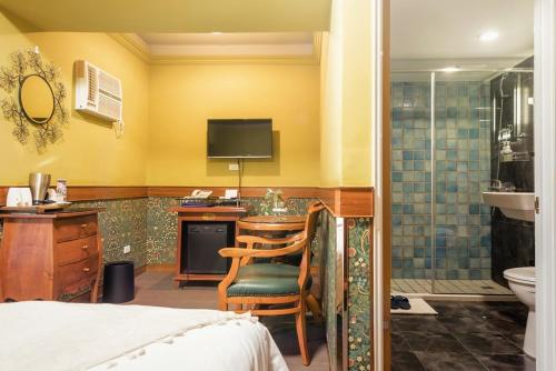a bedroom with a desk and a bathroom with a shower at 翠安儂風旅 in Taitung City