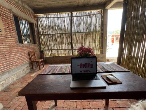 un ordenador portátil sentado en una mesa de madera en un patio en LÍZU Tu casa en un pueblo zapoteca, en Teotitlán del Valle