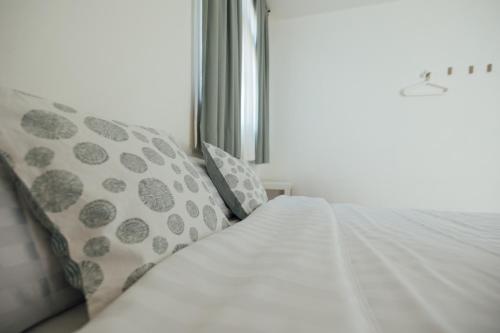 a white bed with pillows next to a window at 5963 Turn Right B&B in Jiaoxi