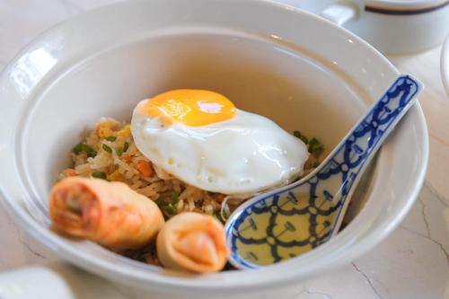 a bowl of food with an egg on top of rice at Tinidee Hideaway Tonsai Beach Krabi - SHA Extra Plus in Tonsai Beach