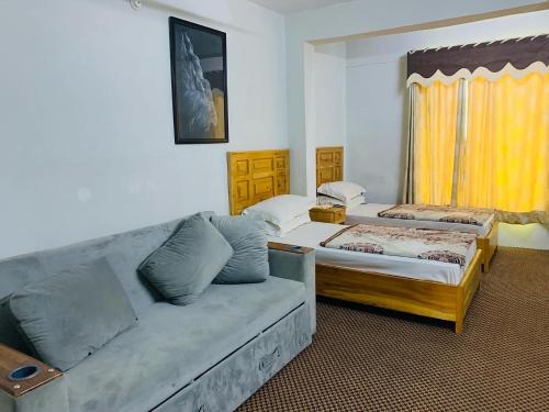 un soggiorno con divano e letto di Naveed Tourist Inn a Gilgit
