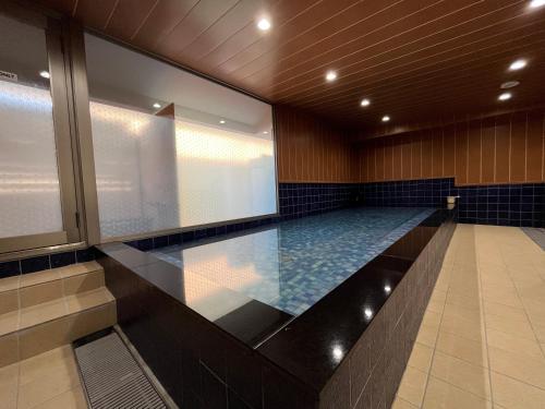 a swimming pool in a building with a large window at HOTEL ERENOA in Nagoya