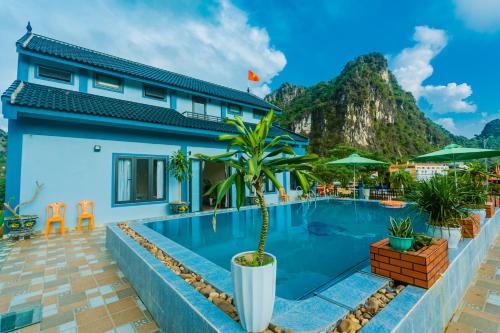 a villa with a swimming pool with a mountain in the background at Phong Nha Green Homestay in Phong Nha