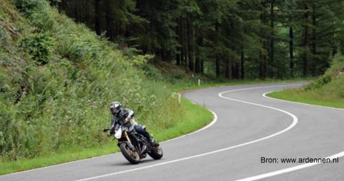a man riding a motorcycle on a winding road at Chalet Durbuy 123 in Durbuy