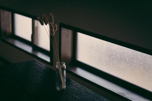 a vase of flowers sitting on a window sill at Kotone Machiya-Inn 京町家旅宿 小都音 in Kyoto