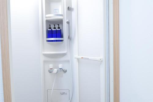 a white refrigerator with bottles of wine in it at Ogu house Beppu in Beppu