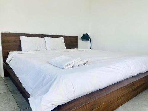 a large white bed with two towels on it at Light House Hostel in Da Nang