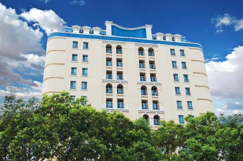 a tall white building with trees in front of it at 翠安儂風旅 in Taitung City
