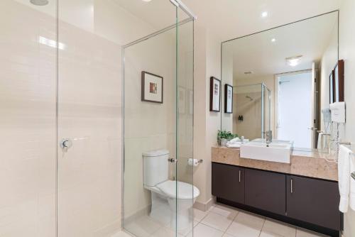 a bathroom with a toilet and a glass shower at Fairway Views – Moonah Apartment 23 in Fingal
