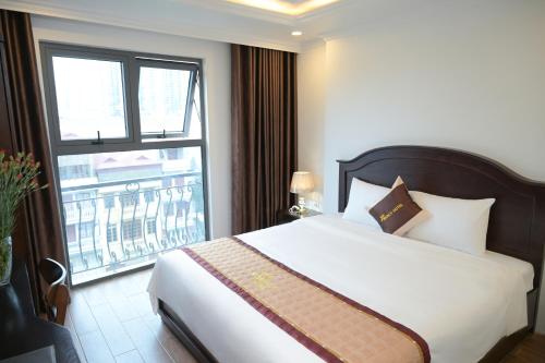 een slaapkamer met een bed en een groot raam bij Mercy Hotel in Hanoi