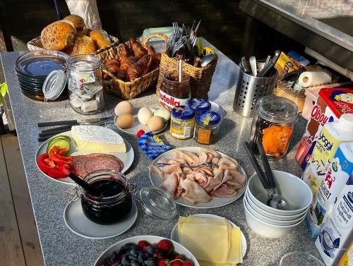 una mesa llena de alimentos con carne y otros alimentos en Vättervy Glamping, en Habo