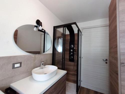 Casa vacanze Caspoggio في كاسبوجيو: حمام مع حوض ومرآة ودش