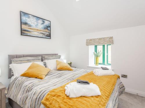 a bedroom with a bed with towels on it at Pogles Wood Cottage in Skipton