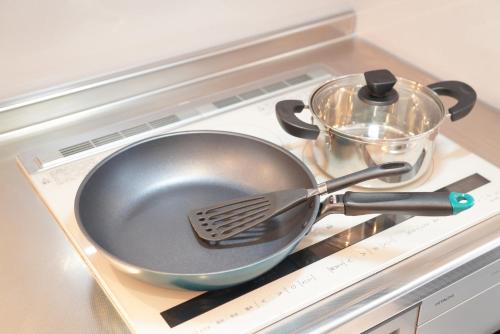 a frying pan and a pot on a stove at 桔恭(KIKYO) in Otaru