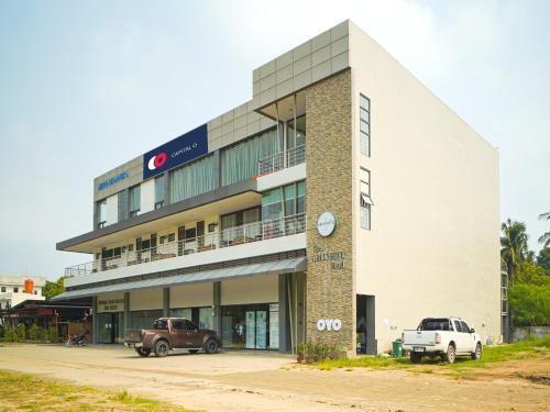 a building with two cars parked in front of it at Capital O OYO 785 The Greenhive Hotel in Lapolapo