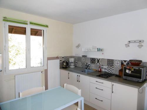 a kitchen with white cabinets and a blue table at Appartement d'une chambre avec jardin clos et wifi a Gap in Gap
