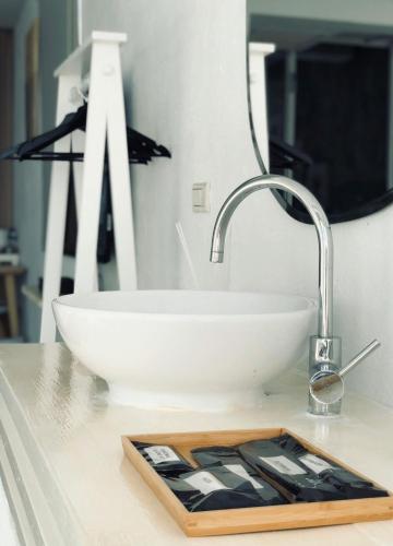 a bathroom counter with a white sink and a mirror at Whose Home Inn in Checheng
