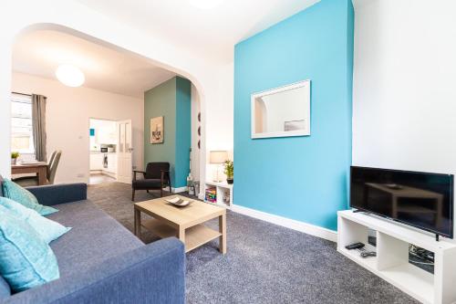 ein Wohnzimmer mit einer Wand mit blauen Akzenten in der Unterkunft Barron House By Horizon Stays in Darlington