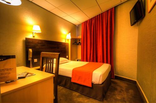 une chambre d'hôtel avec un lit et un bureau avec un ordinateur dans l'établissement Hôtel Des Trois Gares, à Paris