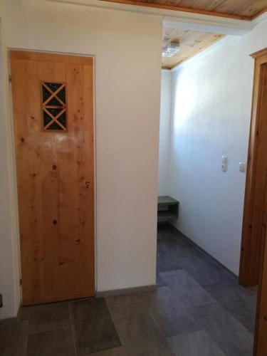 a room with a wooden door and a tile floor at Erlhofer Apartments in Tröpolach
