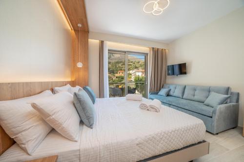 a bedroom with a large bed and a blue couch at Nicole Studios in Ayia Evfimia