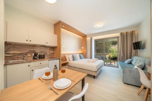 a kitchen and living room with a table and a couch at Nicole Studios in Ayia Evfimia