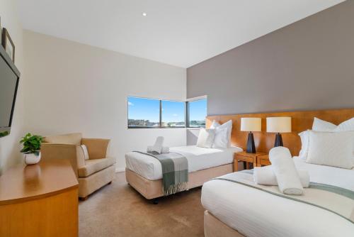 a hotel room with two beds and a couch at Fairway Views – Moonah Apartment 24 in Fingal