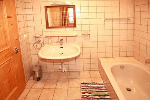 a bathroom with a sink and a bath tub at Mühlenhäuschen in Bad Koetzting