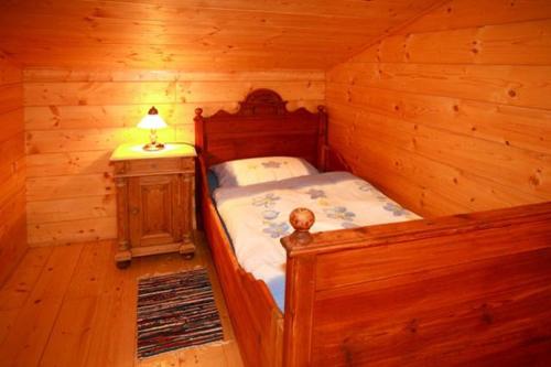 a bedroom with a bed in a log cabin at Mühlenhäuschen in Bad Koetzting
