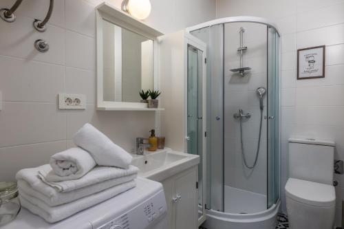a white bathroom with a shower and a sink at Agostini Residence - SELF CHECK-IN ONLY in Rijeka
