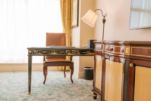 a desk with a chair in a room at Qingdao Jianxin International Hotel in Qingdao