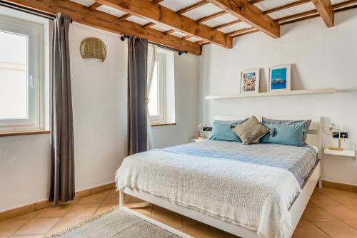 a bedroom with a bed with blue pillows at Casa Agnès in Mahón