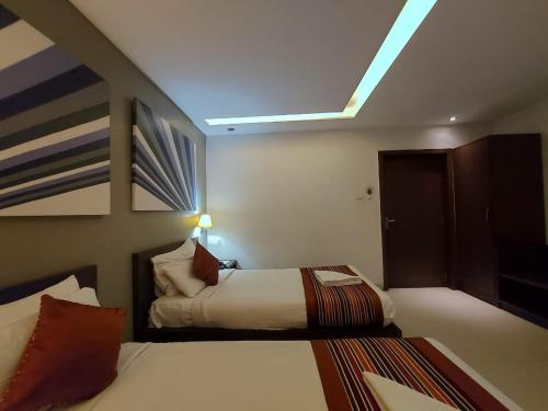 a bedroom with two beds and a sloped ceiling at Orbit Hotel - Bagdogra in Bāghdogra