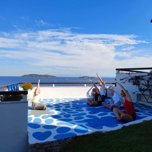 a group of people sitting on a blue and white carpet at VILLA ALEXIS in Megali Ammos