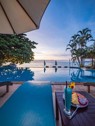 a table with a plate of food next to a swimming pool at Sea Valley Resort in Lipa Noi