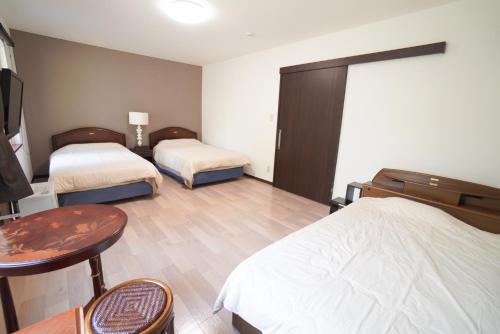 a hotel room with two beds and a table and a table sidx sidx at 桔恭(KIKYO) in Otaru