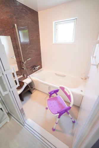 a bathroom with a pink and purple chair in a room at 桔恭(KIKYO) in Otaru