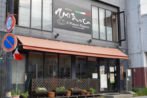 a building with a red awning on a street at 桔恭(KIKYO) in Otaru