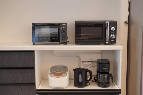 a kitchen with two microwaves and a coffee maker at 桔恭(KIKYO) in Otaru